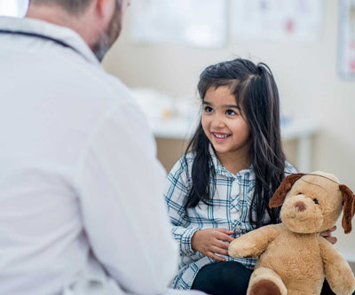 child in clinic with teddy bear