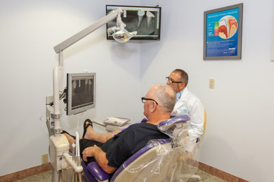 Dr. E shows an X-ray of a patient's teeth.